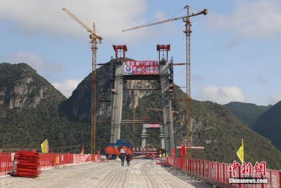 11月22日，正在建设中的峰林特大桥。当日，随着1470吨装配化预制中横梁提升到位，贵州省黔西南布依族苗族自治州兴义环城高速公路峰林特大桥4号主塔中横梁成功吊装，由此刷新了山区峡谷桥梁预制吊装混凝土构件重量世界记录。峰林特大桥是属全线控制性工程。大桥跨越马岭河峡谷，全长1163米，主跨采用550米悬索桥，桥面离谷底364.2米，是中国山区第一座大跨径钢混叠合梁悬索桥。中新社记者 瞿宏伦 摄